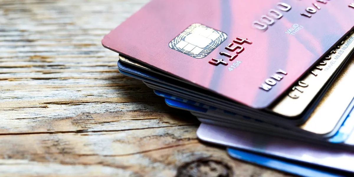 Stack of credit and debit cards on a wooden surface