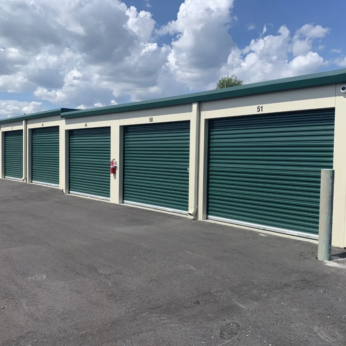 Green roll-up doors on numbered drive-up self storage units